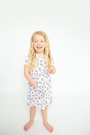 Young girl dress in a popsicle sundress smiling
