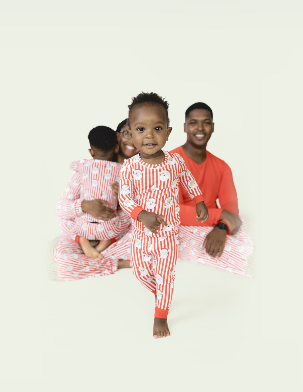 A family matches in the Vintage Striped Santa holiday loungewear in different styles.
