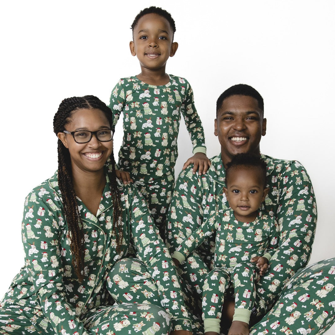 A family wears matching holiday pajamas in a green holiday dog print.