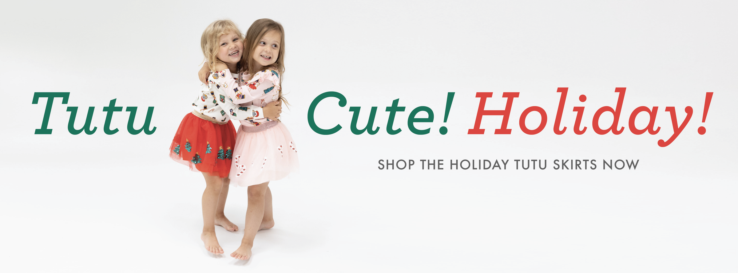 Two little girls hug while wearing Christmas themed Tutu Skirts.