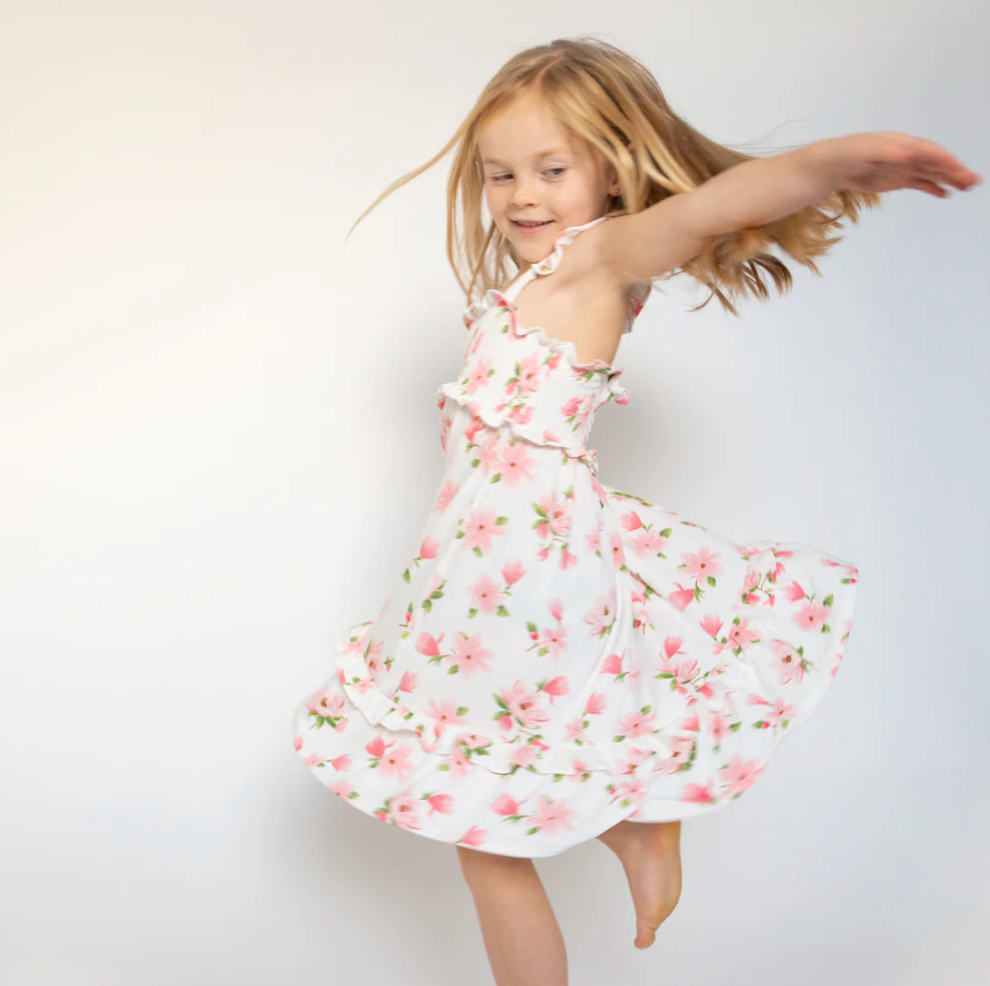 A young girl in a Spring dress twirling