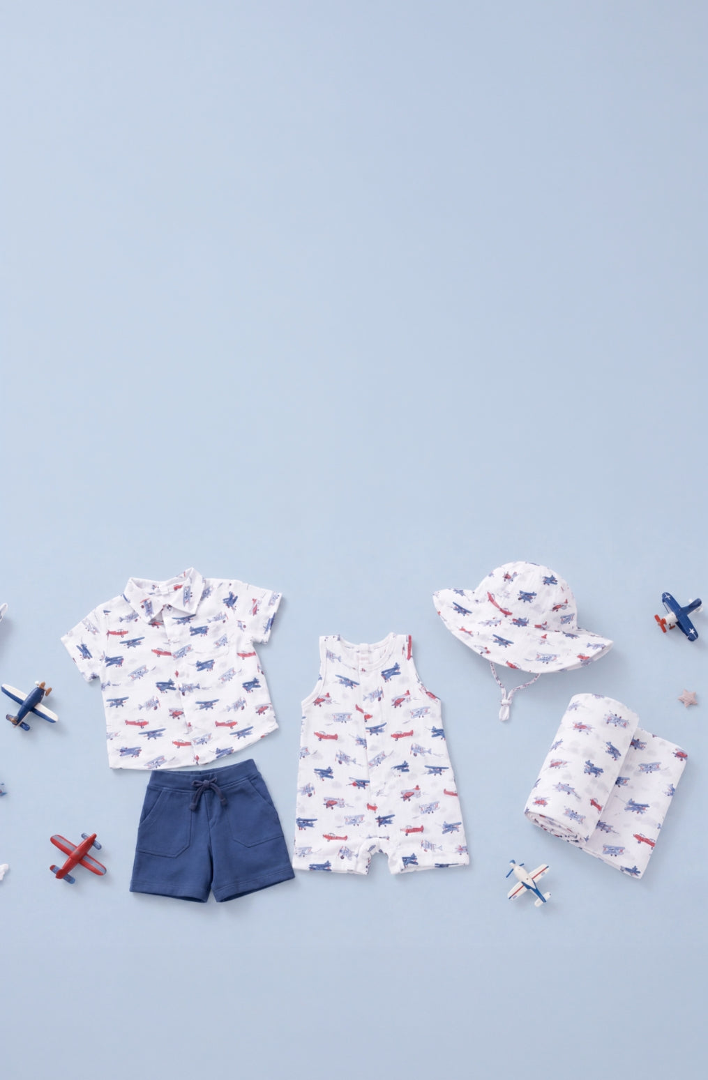 Children's clothing with a vintage airplane pattern on a light blue background