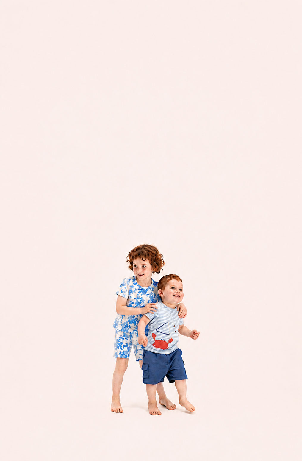 Two children standing on a light pink background